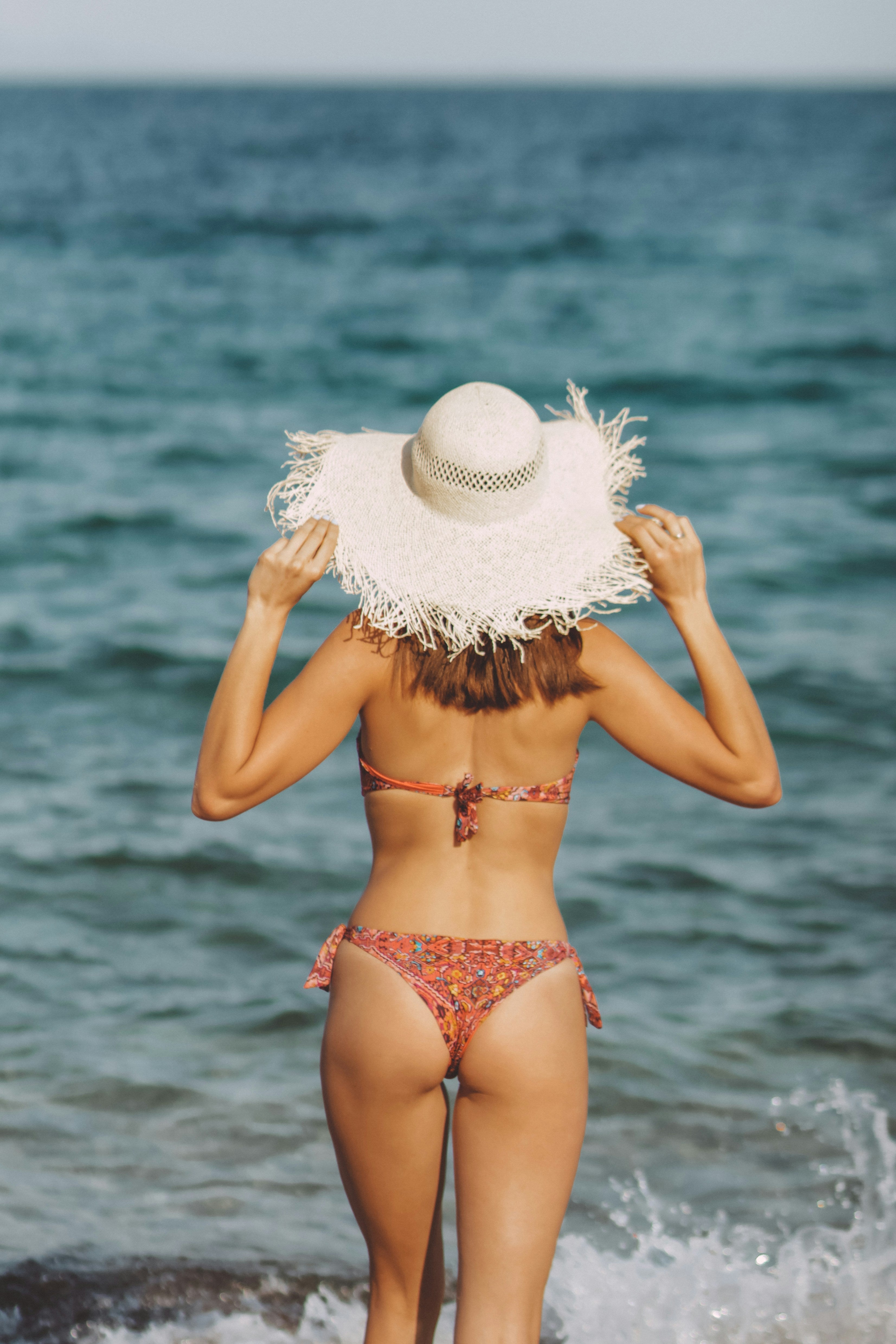 Women laughing on the beach in minimalist bikinis — Vesyn